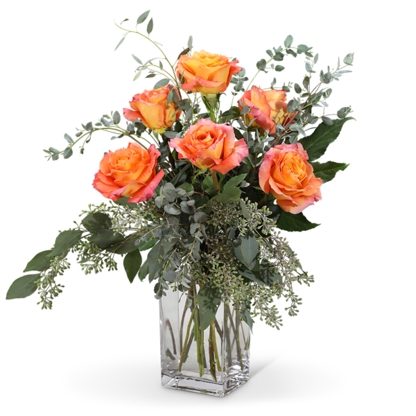 Orange roses in a clear glass vase with airy greenery
