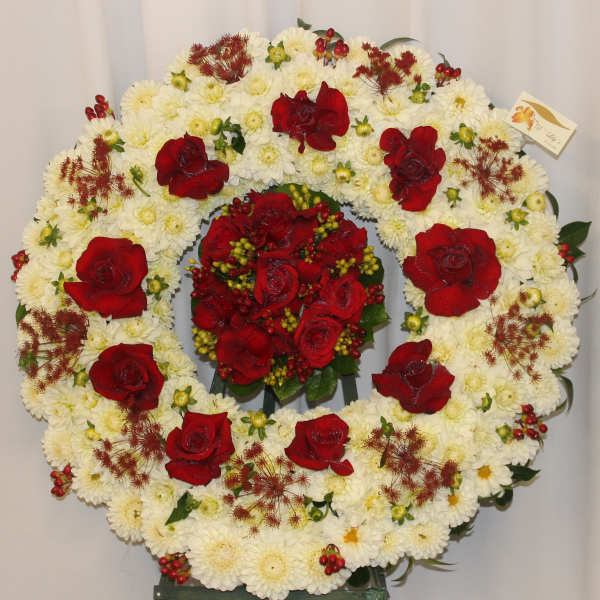 Heart-shaped floral wreath of white chrysanthemums and red roses