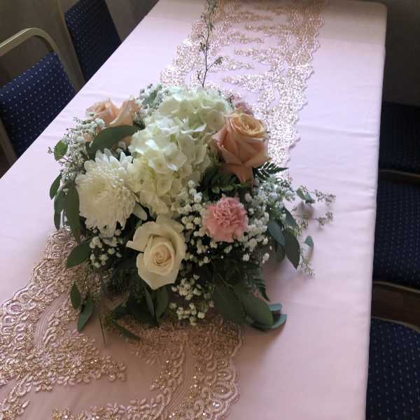 Pink and gold table runner with a pastel floral centerpiece