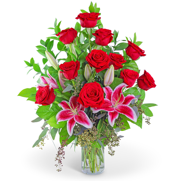 Red roses and pink lilies in a clear glass vase