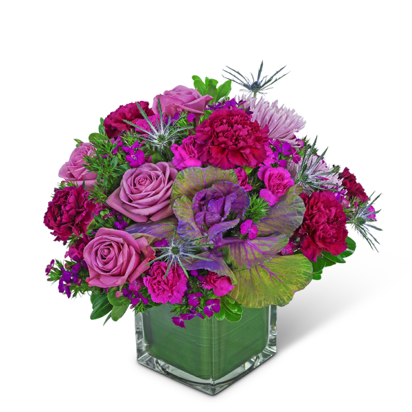 Pink and purple floral arrangement in a clear square vase