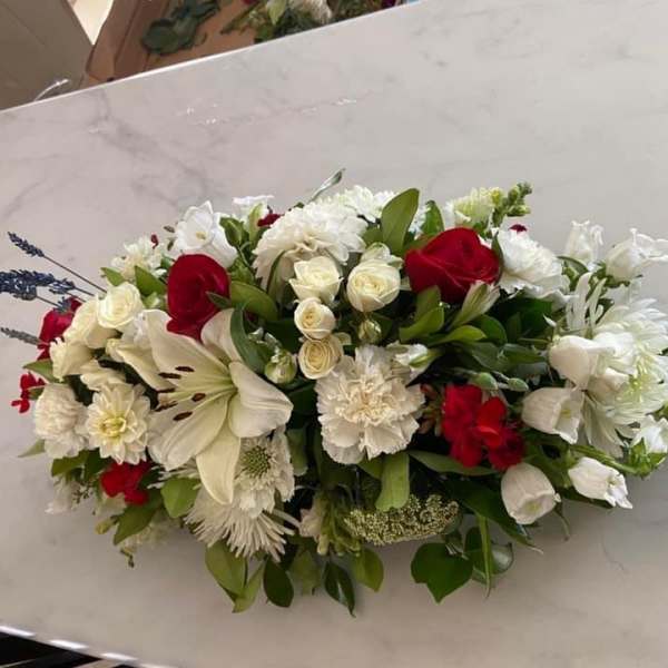 Low floral arrangement with red and white blooms on a table