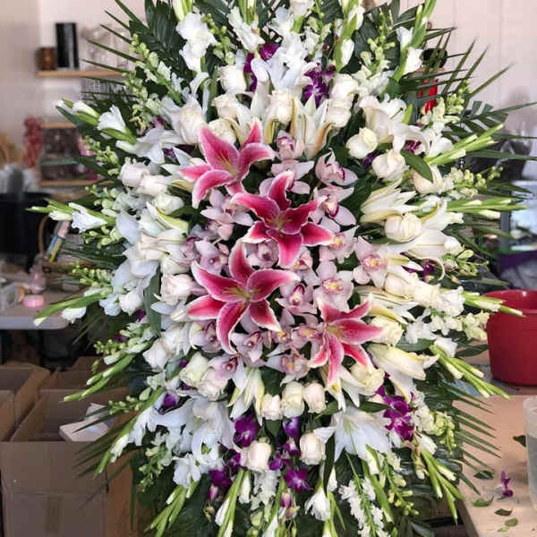 Large standing spray of white and pink lilies with orchids