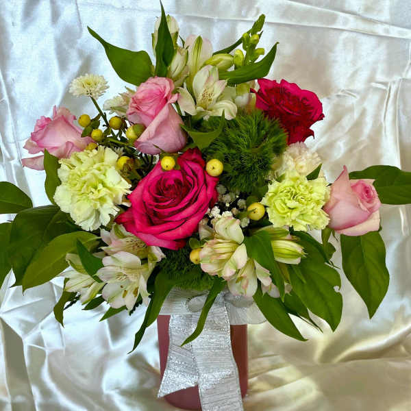 Bouquet of pink and red roses with white flowers in a pink vase
