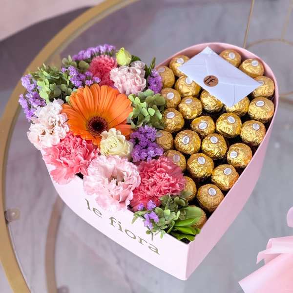 Heart-shaped box with flowers and gold-wrapped chocolates