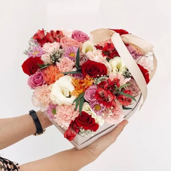 Heart-shaped bouquet box filled with mixed pink, red, and white flowers