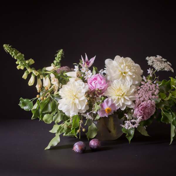 Low floral arrangement with white and pink blooms in a vase