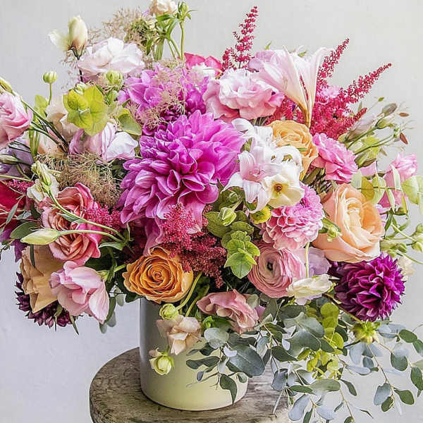 Mixed bouquet of pink, peach, and white flowers in a vase