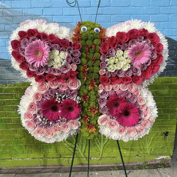 Butterfly-shaped floral standing spray with pink and white blooms
