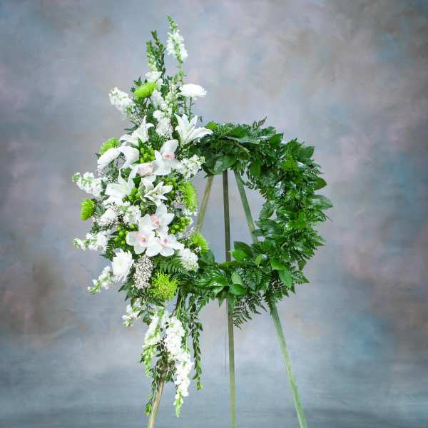 White floral funeral wreath on a standing easel