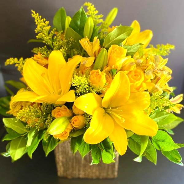 Yellow lily and rose bouquet in a square container