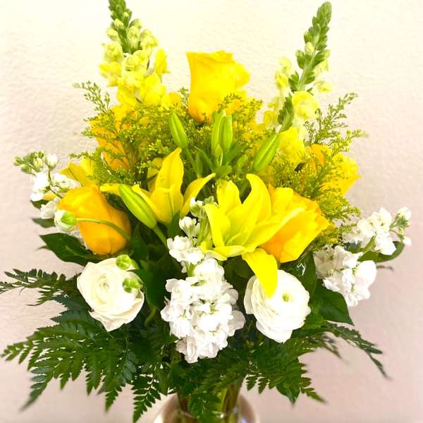 Yellow and white floral arrangement in a clear glass vase