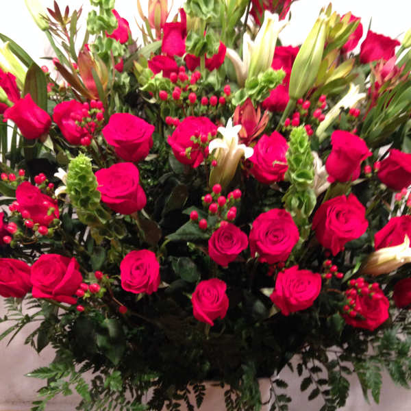 Large bouquet of hot pink roses with white lilies in a white vase