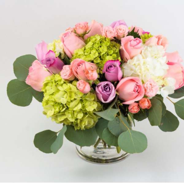 Pink and purple roses with hydrangeas in a glass vase