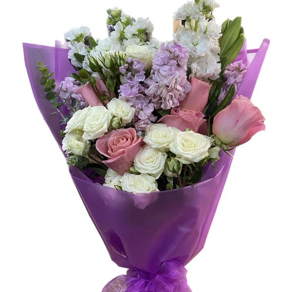 Bouquet of pink and white roses with lavender flowers wrapped in purple paper