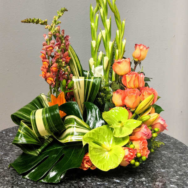 Tropical floral arrangement with orange roses and green anthuriums