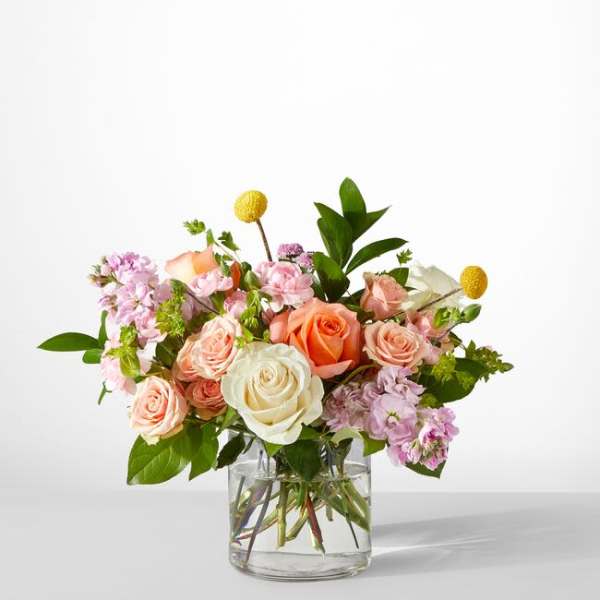 Bouquet of pink and peach roses in a clear glass vase