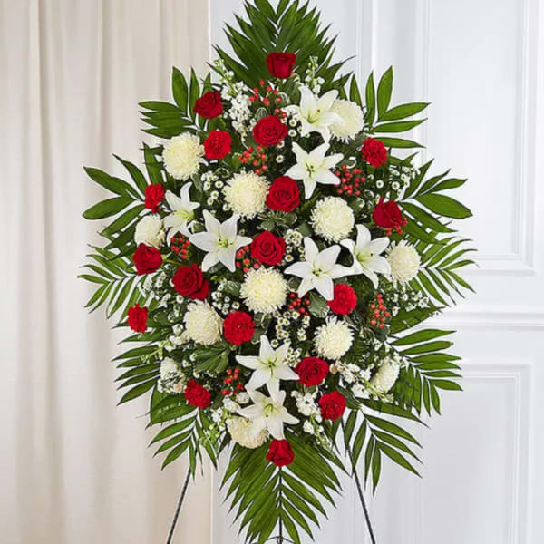 Standing floral spray with red roses, white lilies, and white pompons