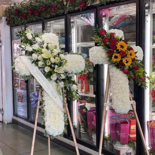 Two large floral standing sprays on easels with white and red flowers