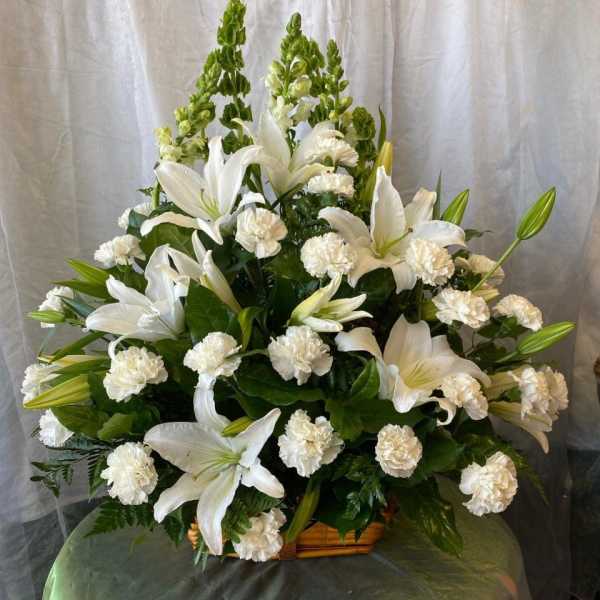 White lilies and carnations arranged in a basket