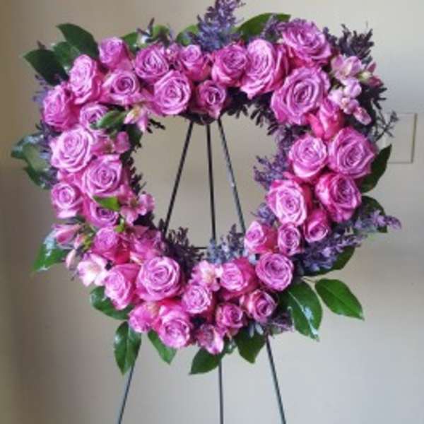 Pink rose wreath on a black stand