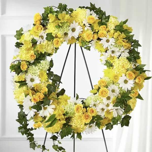 Yellow and white floral wreath on a black stand