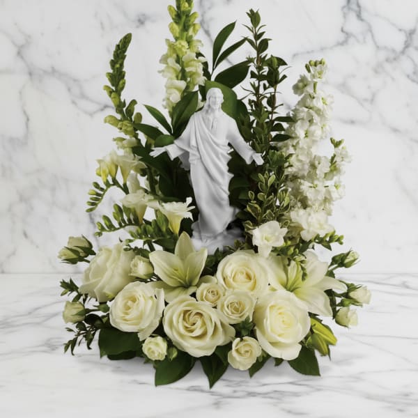 White floral arrangement with a small statue in the center