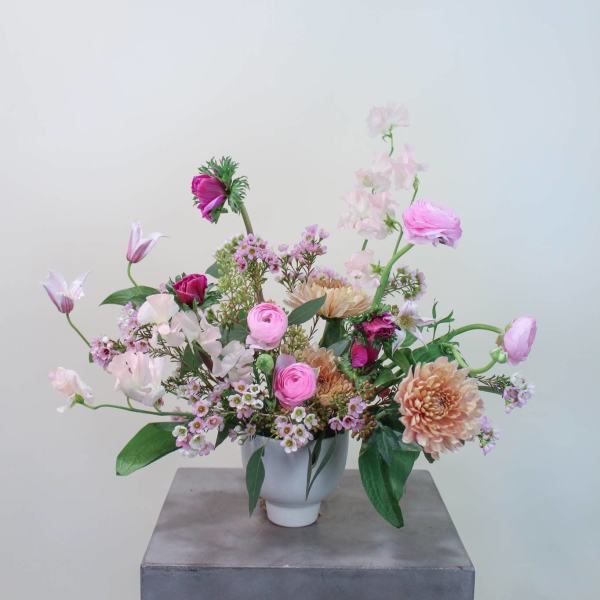 Pink and peach mixed flower arrangement in a white vase