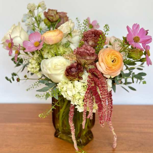 Mixed pastel bouquet in an amber glass vase