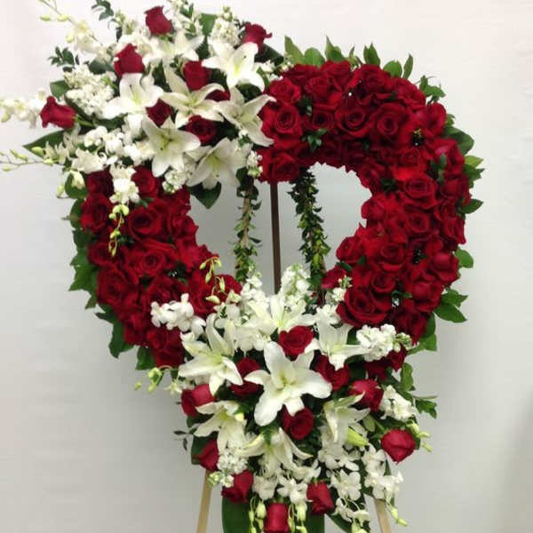 Heart-shaped standing floral tribute with red roses and white lilies