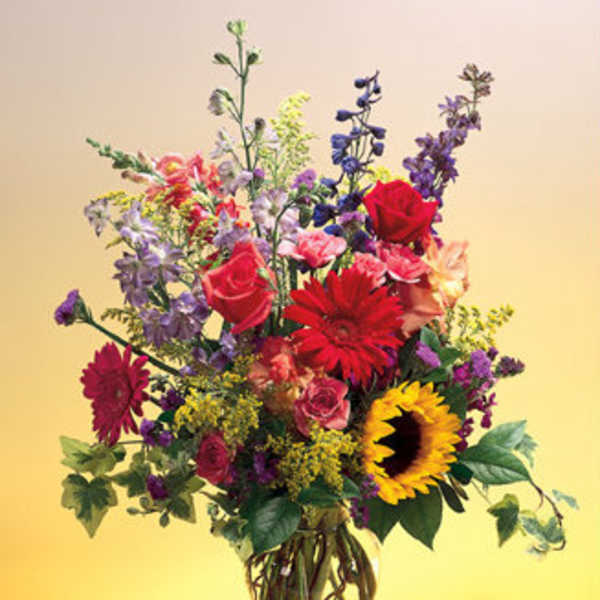 Mixed bouquet of colorful flowers in a clear glass vase