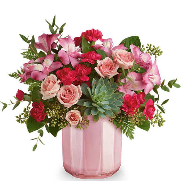 Pink roses and lilies arranged in a pink glass vase