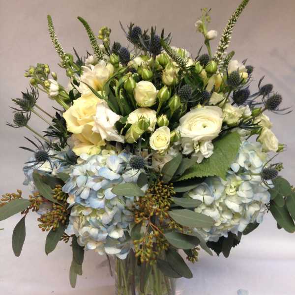 Bouquet of white and pale blue flowers in a glass vase