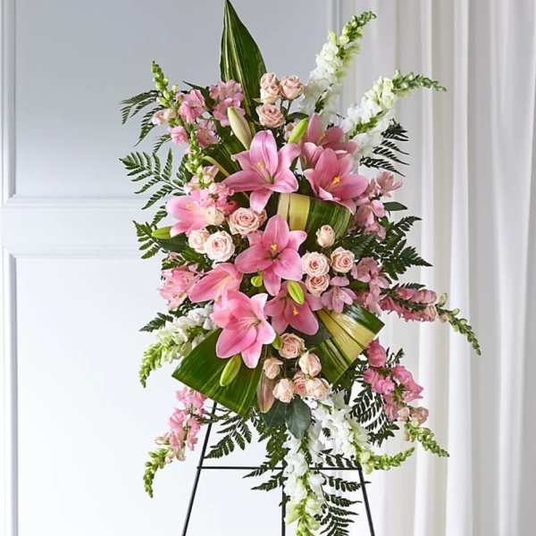 Tall pink and white floral standing spray on a black easel