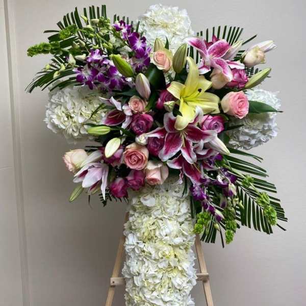 Large floral standing spray with lilies, roses, orchids, and white hydrangeas