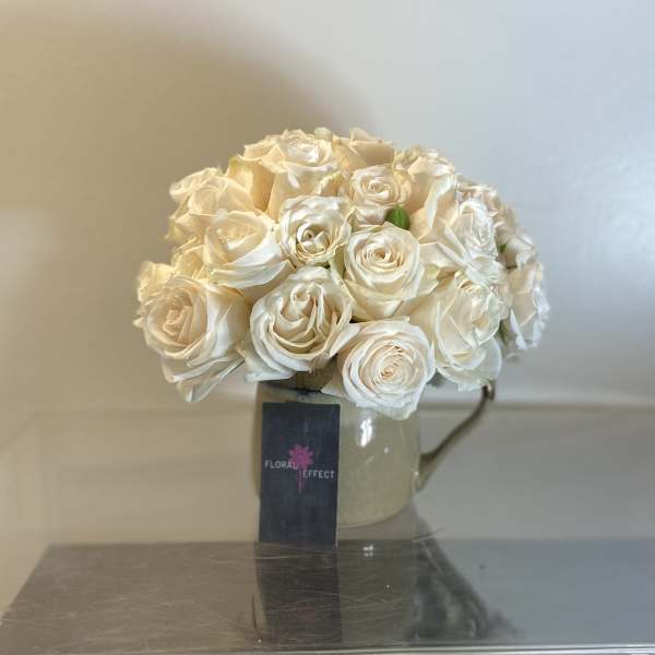 Cream rose bouquet in a glass mug