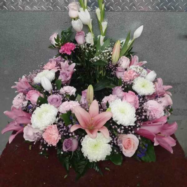 Pink and white floral spray with lilies, roses, and carnations