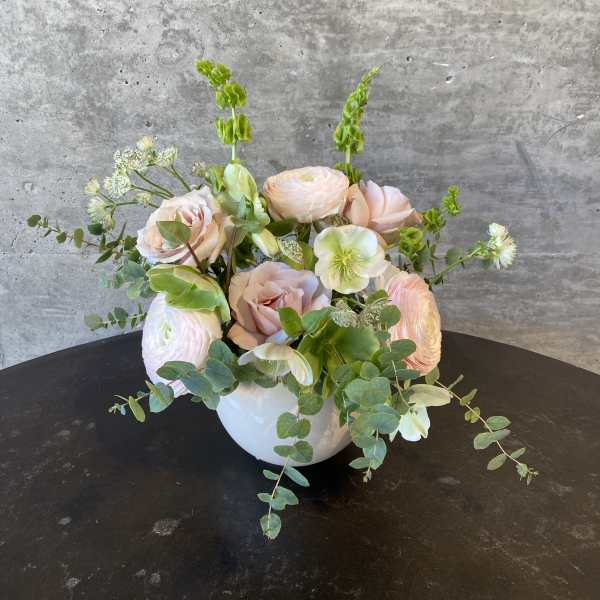 Pastel floral arrangement in a white bowl vase with roses and ranunculus