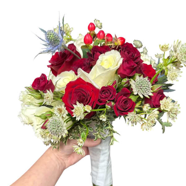 Handheld bouquet of red and white roses with small accent flowers