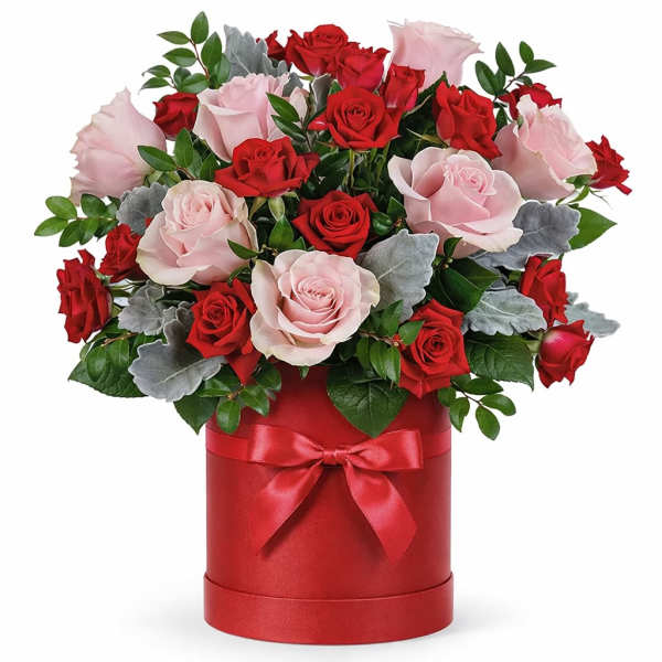 Bouquet of red and pale pink roses in a red hat box with a ribbon