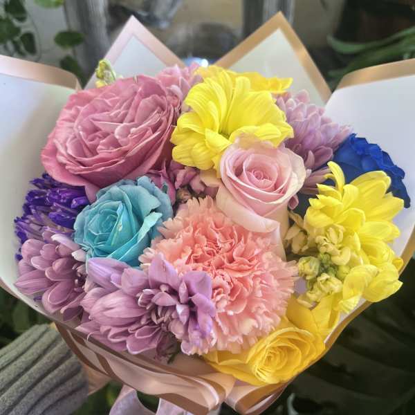 Colorful bouquet of roses, chrysanthemums, and carnations wrapped in pastel paper