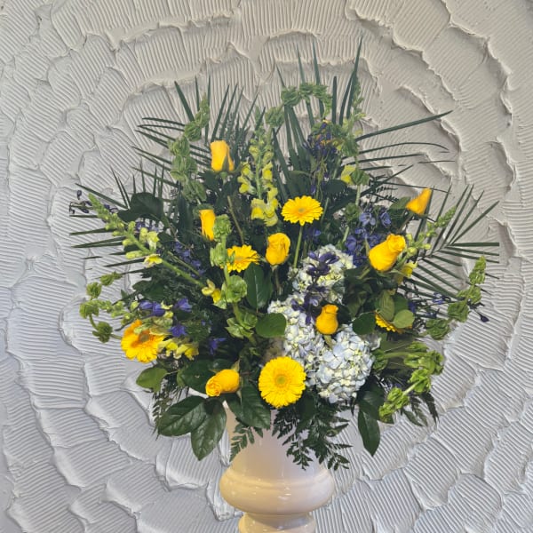 Yellow roses and mixed blooms in a white vase