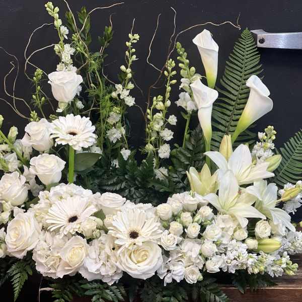 White floral arrangement with roses, gerbera daisies, lilies, and calla lilies