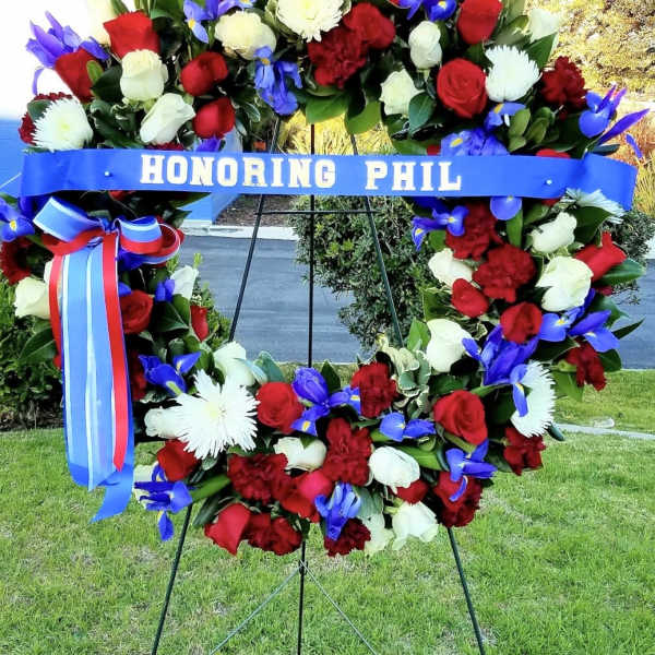 Large floral wreath with red, white, and blue flowers on an easel