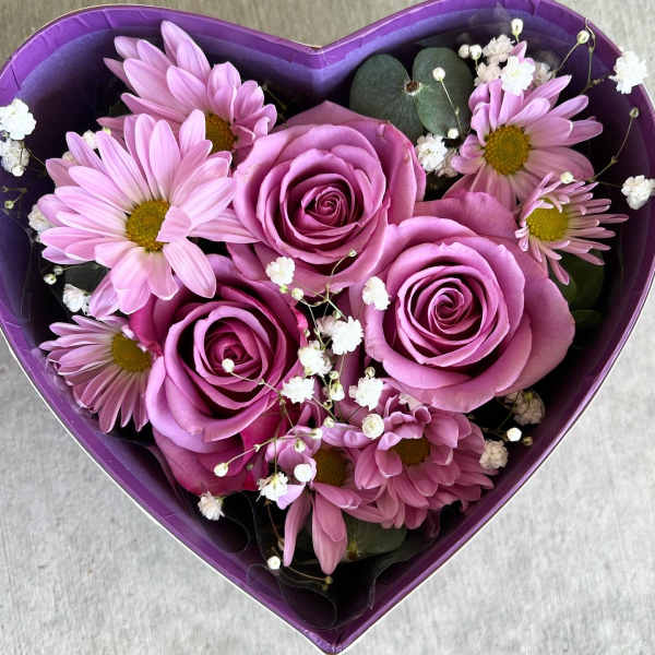 Heart-shaped box with pink roses and daisies