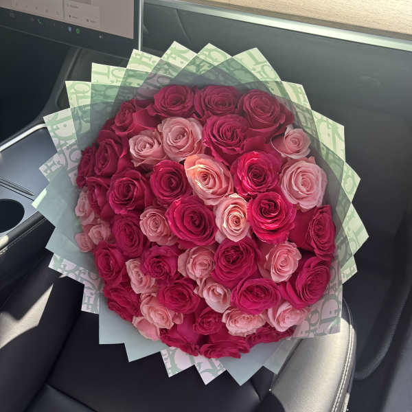 Bouquet of pink and magenta roses wrapped in patterned paper