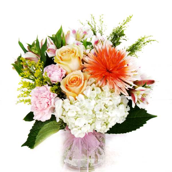 Mixed bouquet in a glass vase with roses, hydrangea, and lilies