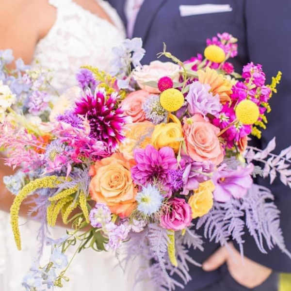 Bride and groom holding a colorful wedding bouquet
