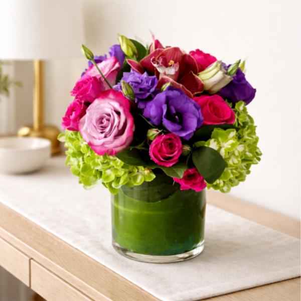Pink, purple, and red flowers arranged in a glass vase