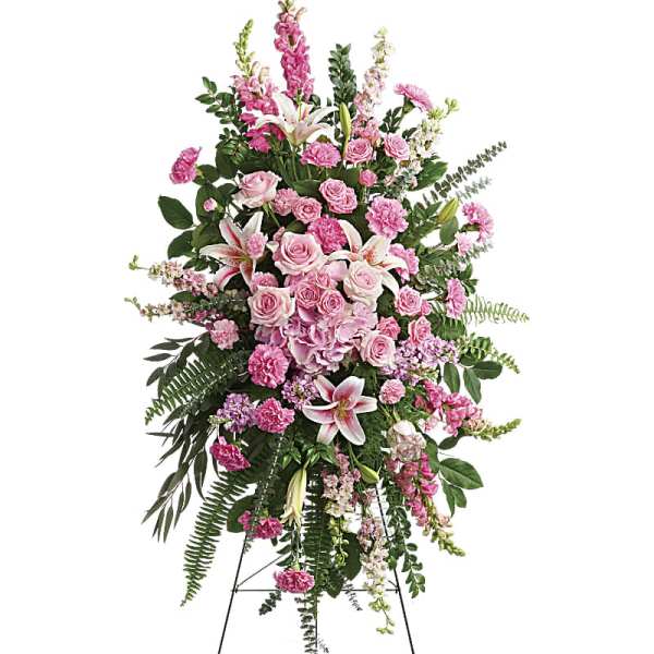 Tall pink and white standing spray of roses, lilies, and carnations on a metal easel